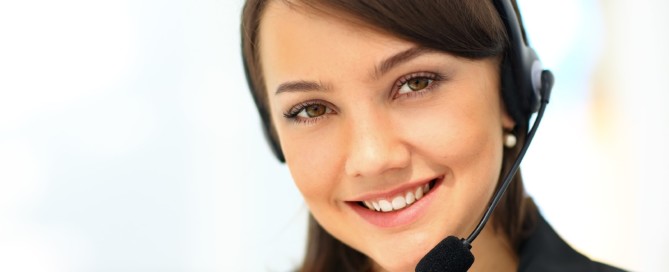 A professional young woman with a headset smiling, representing a skilled cold caller working for a cleaning service in a business environment