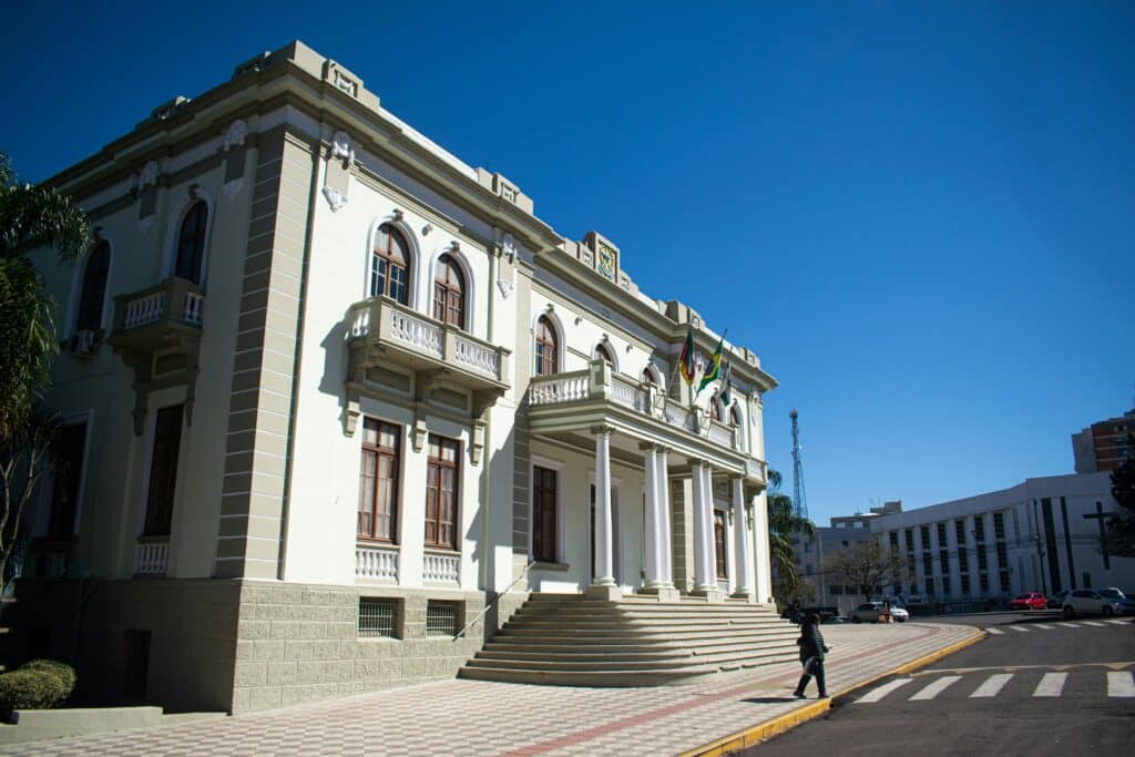 View of a local government city hall with classical architecture under a clear blue sky, illustrating potential cleaning contract opportunities for local businesses.