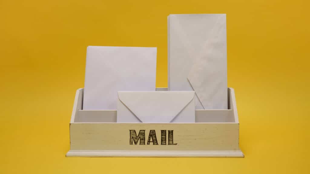 Wooden box filled with envelopes for direct mail marketing in an office