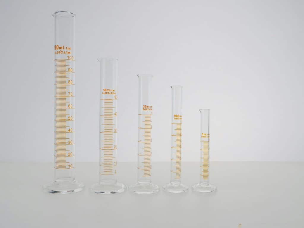 An array of graduated cylinders, symbolizing the strategic stages of developing a successful cleaning business.