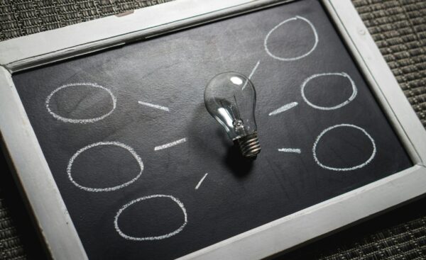 Light bulb on a chalkboard with circles, representing ideas for attracting an audience through janitorial SEO strategies.