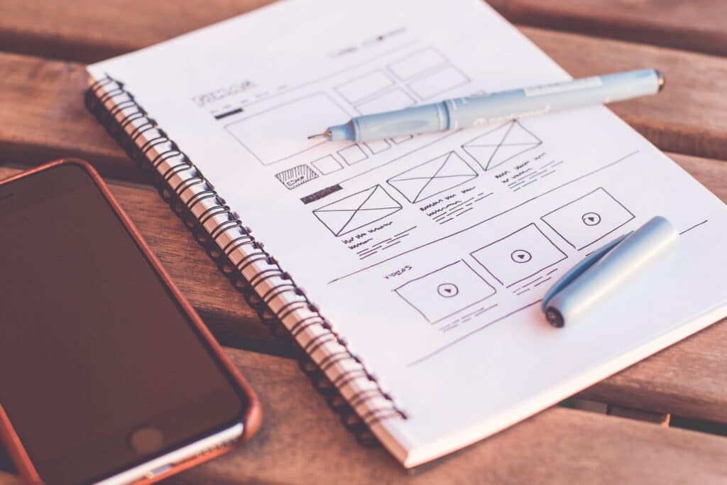 A wireframe sketch on a notebook for a cleaning service website aimed at improving user engagement.