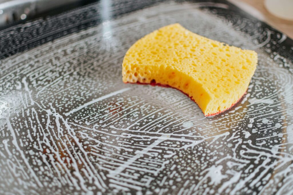 Yellow sponge cleaning a soapy surface