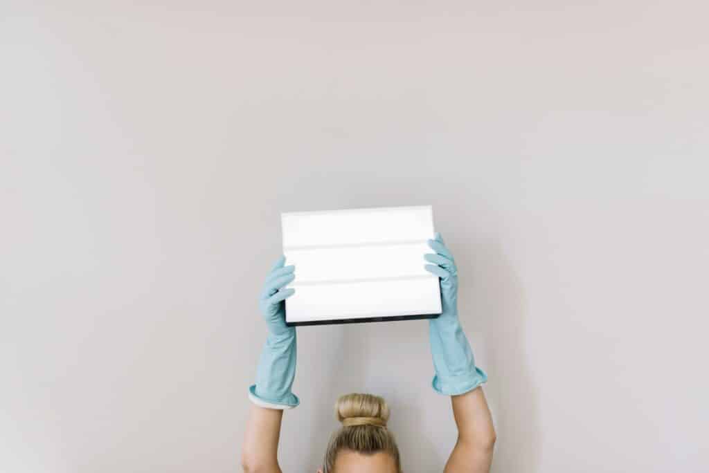 A person wearing blue gloves holding a bright lightbox overhead, symbolizing motivation and achievement