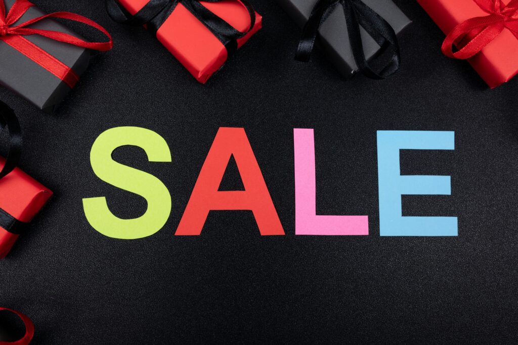 Colorful SALE letters with gift boxes, representing successful promotion strategies for cleaning services.
