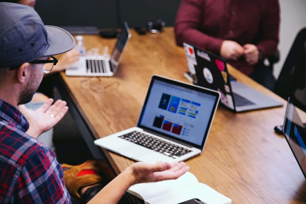 Team in a meeting discussing off-page SEO strategies for cleaning business success with laptops open on a wooden table.