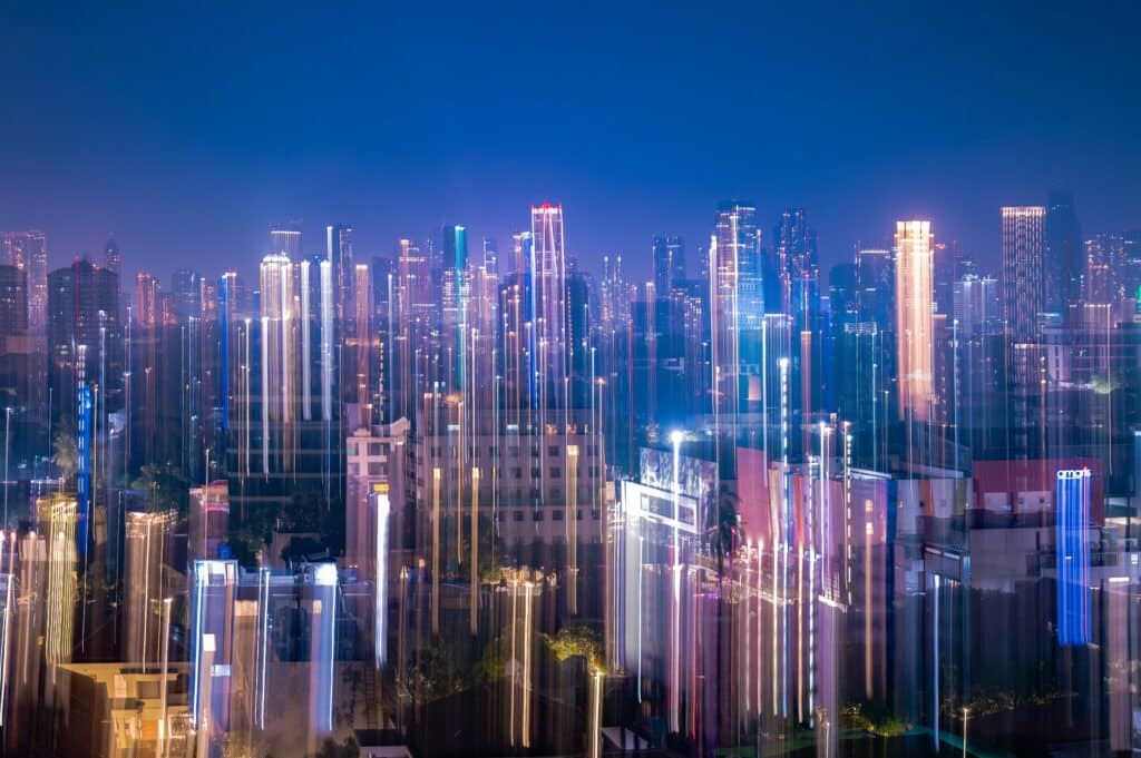 Vibrant cityscape at night with blurred vertical lights representing growth and community connections