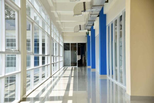 A spotless commercial hallway with polished floors and bright windows, representing the high standards of profitable cleaning contracts.