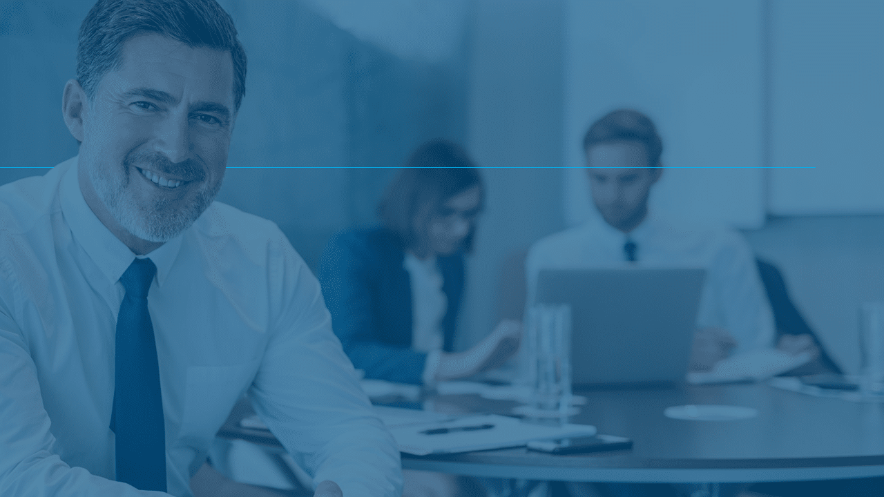 Smiling businessman in a professional office setting with colleagues working in the background, representing AI receptionist solutions for commercial cleaning services.