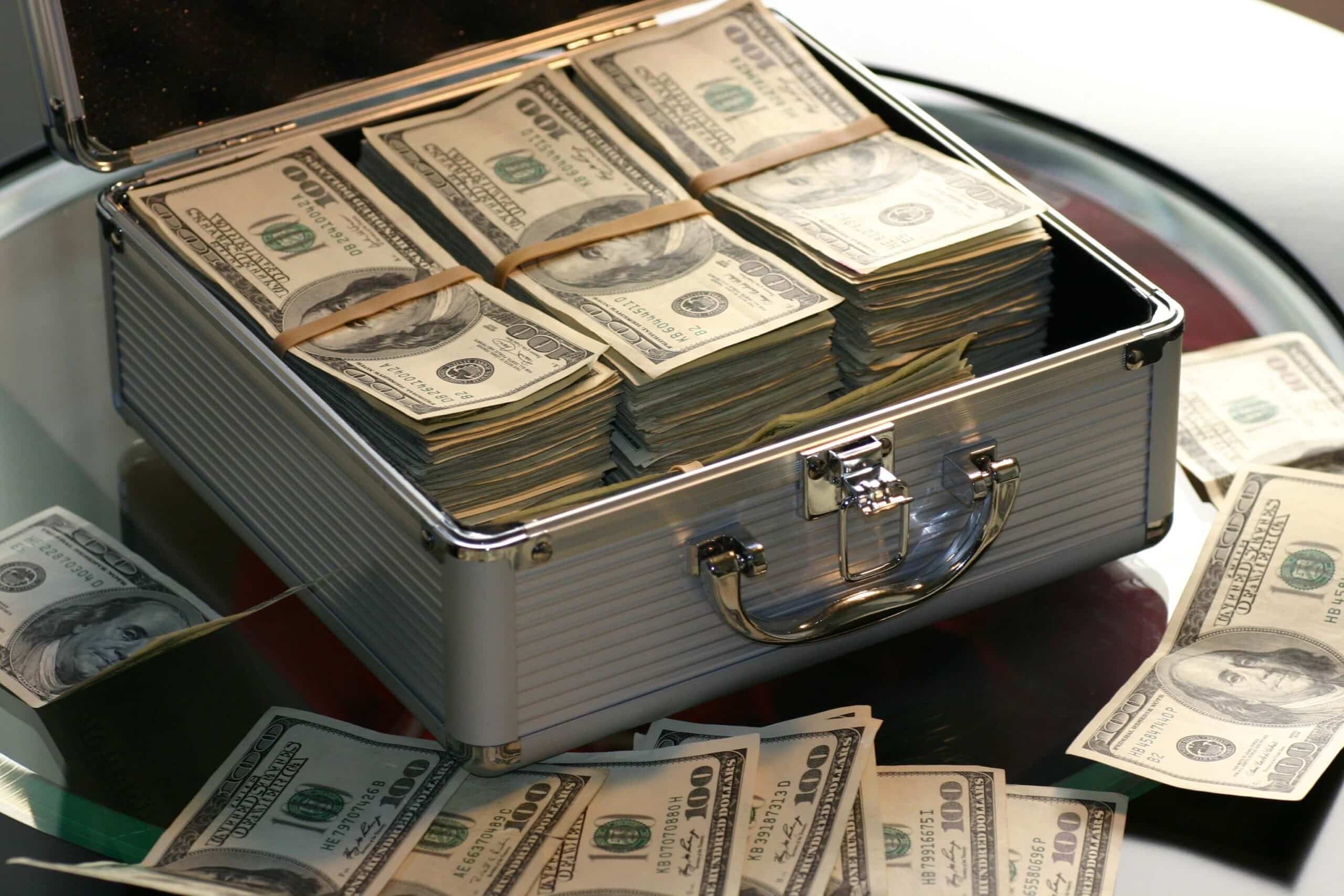 Briefcase full of hundred-dollar bills representing capital to grow a cleaning business